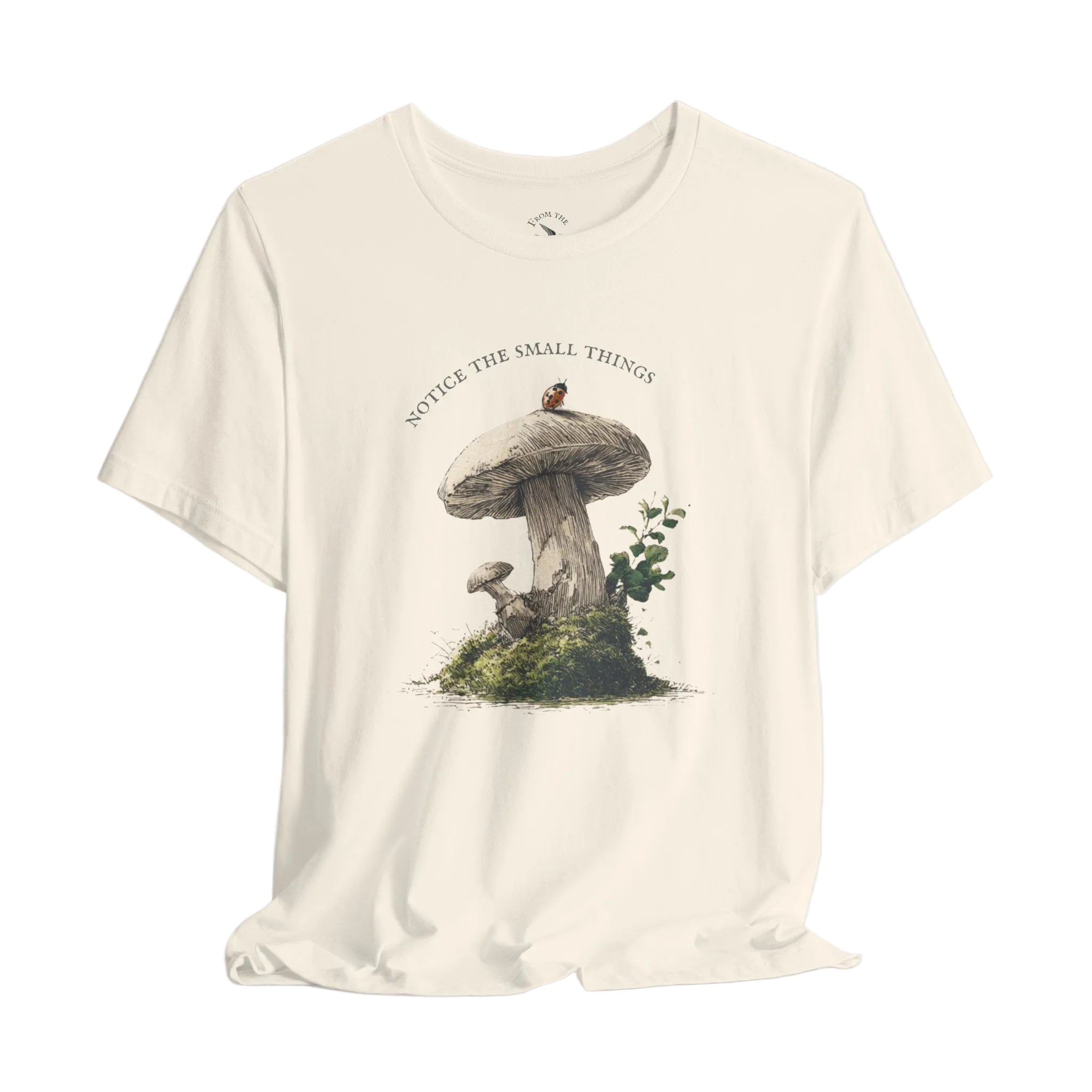 White t-shirt with mushroom graphic and text 'Notice the small things' on a light gray background